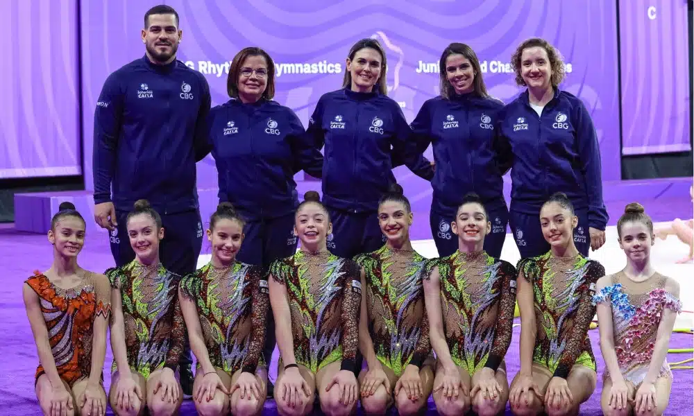 Conjunto Brasileiro Juvenil de Ginástica rítmica ajoelhado enquanto a comissão técnica está de pé