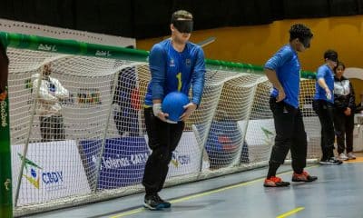 Fábio Junior segura a bola na ala direita antes do arremesso. Ao seu lado, o pivô Victor Hugo e o ala esquerdo Wellington Eri estão posicionados próximos da trave do Brasil, que usa camisa azul com detalhes em amarelo no Mundial de Jovens (Foto: Taba Benedicto/CBDV)