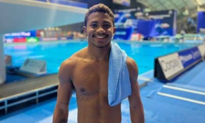 Isaac Souza posa para foto com as plataformas de saltos ao fundo