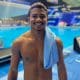 Isaac Souza posa para foto com as plataformas de saltos ao fundo