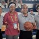 Janeth Arcain ao lado de ábtiras de um jogo de basquete