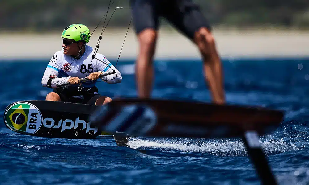 Na imagem, Lucas Fonseca equilibrando-se com a prancha e sua vela de kite.