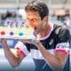 Na imagem, Marcelo Melo mordendo o bolo de comemoração à sua milésima partida no circuito da ATP.