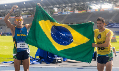 Yeltsin Jacques e atleta-guia Edelson Ávila com bandeira do Brasil no Mundial de atletismo paralímpico