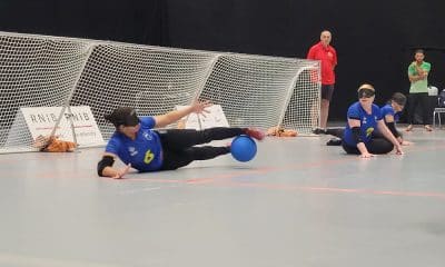 Na imagem, na ala direita do Brasil, Kátia estica as pernas na posição de chicote e defende a bola com os pés; ao seu lado, pivô Gaby aguarda desfecho do lance.