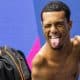 Gabriel Araújo posa para foto piscando olho. Ele está em uma cadeira de rodas à beira da piscina - Jogos Parapan-Americanos Santiago-2023
