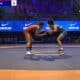 Mayara Ramos, que está à direita da imagem e veste traje azul, luta contra rival na estreia do Mundial Sub-20 de Wrestlig