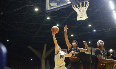 Jogador do Mogi Basquete tenta alcançar a cesta marcado por atleta do Sesi Franca no Paulista de basquete