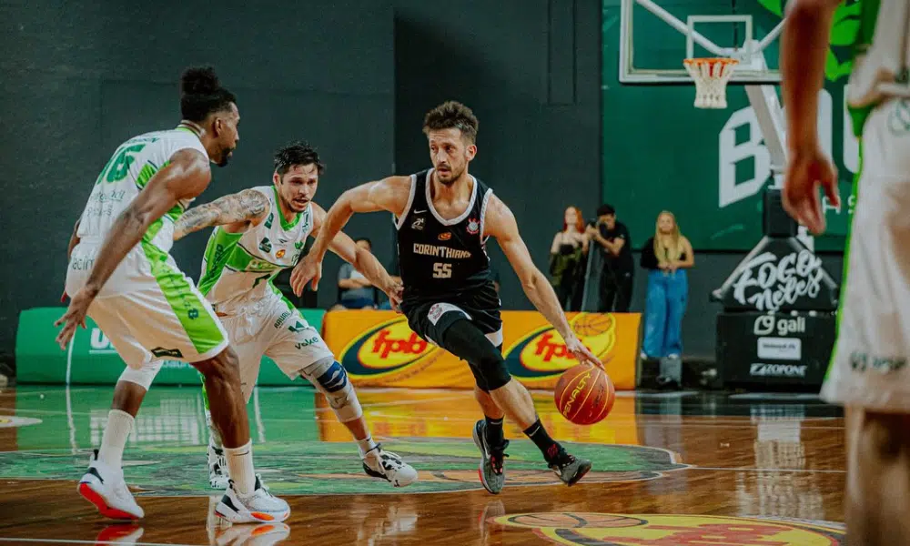 Jogador do Corinthians conduz a bola marcado por atleta do Bauru em jogo do Paulista de basquete masculino