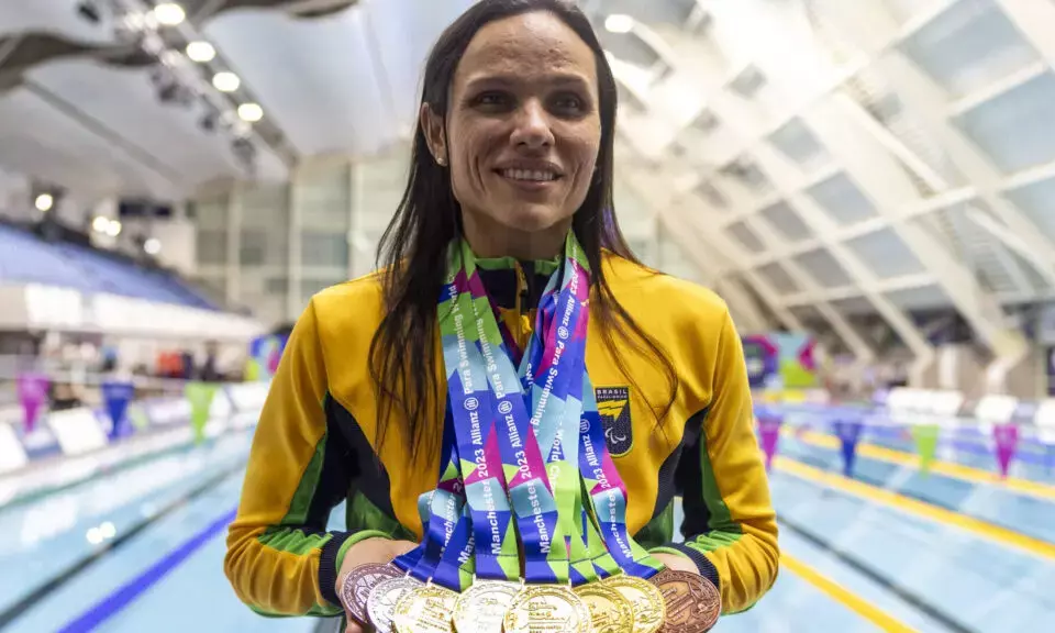 Carol Santiago posa para foto com oito medalhas do Mundial de Manchester.