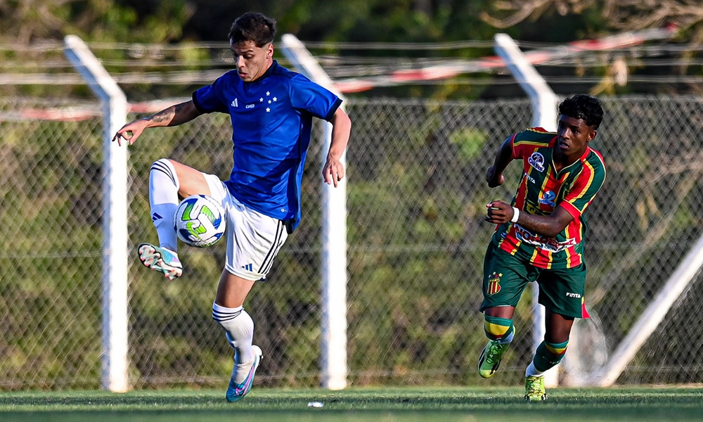Na imagem, jogador do Cruzeiro dominando a bola e jogador do Sampaio Corrêa correndo para marcá-lo.