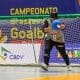 Jéssica Vitorino em ação de arremessar a bola. Ela está sozinha na imagem e, fundo, há o o gol e a logo do Campeonato Brasileiro de goalball, sob um banner roxo (Foto: Taba Benedicto/CBDV)