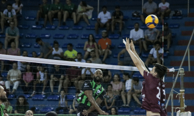 Jogador do América ataca bola contra bloqueio em partida do Campeonato Mineiro de vôlei masculino