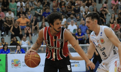 Jogador do São Paulo protege bola contra jogador do São José pelo Paulista de basquete masculino