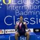 Na imagem, Jonathan Matias sentado no lugar mais alto do pódio com sua medalha.