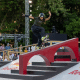Rayssa Leal faz manobra sobre grande corrimão no Pro Tour de Lausanne de skate street; Kelvin Hoefler assiste ao fundo