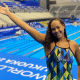 Celine Bispo posa para foto em frente à piscina no Mundial Júnior de natação