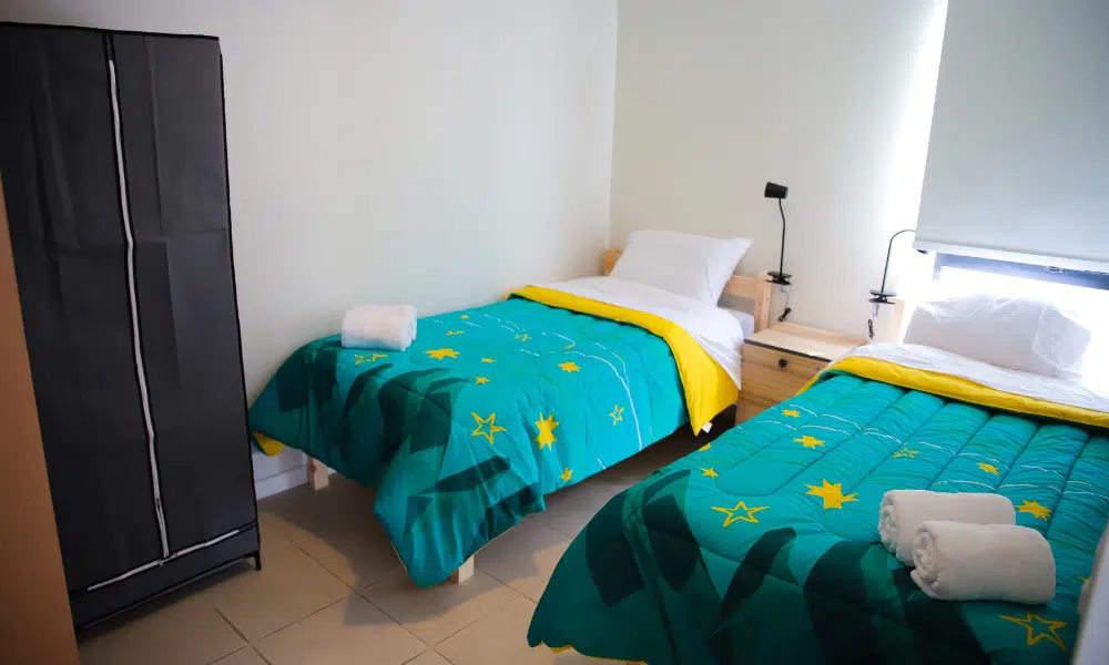 duas camas em um dos quartos da Vila Pan-Americana de Santiago