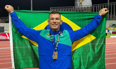 Vinícius de Brito posa para foto com a bandeira do Brasil