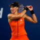 Bia Haddad veste laranja e usa viseira preta e faz movimento de rebatida, com a raquete na mão, ao fundo da cabeça, no WTA 1000 de Pequim. Ela jogou ao lado da russa Veronika Kudermetova