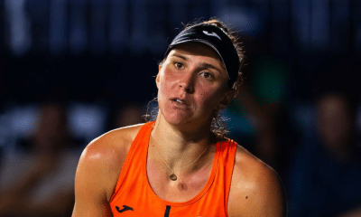 Bia Haddad Maia, usando laranja e viseira, faz cara de lamentação durante o WTA 1000 de Pequim
