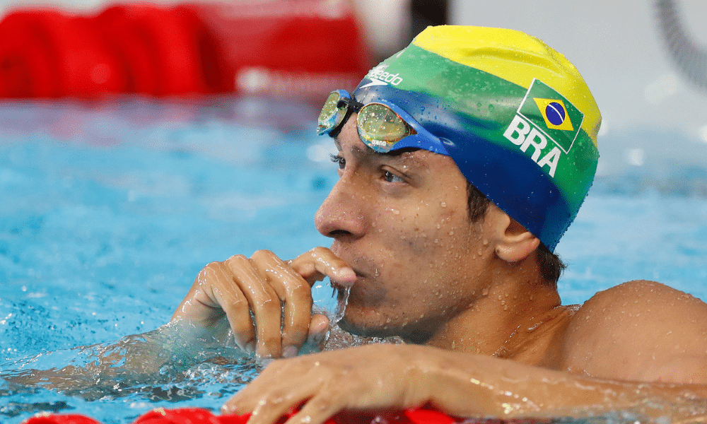 Breno Correia, de touca verde e amarela, está na piscina, de lado, e olha para frente no s Jogos Pan-Americanos de Santiago-2023