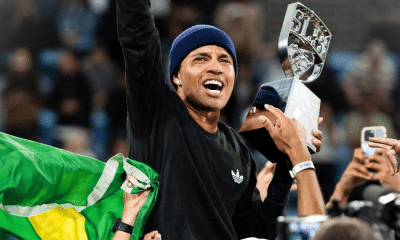 Felipe Gustavo está de touca e de roupa preta e segura o troféu da SLS Sydney, enquanto vibra. Rayssa Leal também foi ao pódio