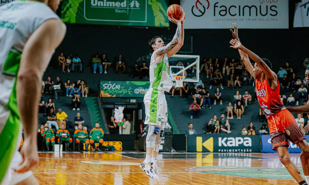 Jogador do Bauru Basket salta para arremessar em parida pelo Campeonato Paulista de basquete masculino