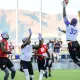 Jogador salta para receber bola em uma partida de flag football, que agora é esporte olímpico