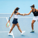 Luisa Stefani e Ingrid Martins se cumprimentam, uma com a raquete em cada mão, sobre a quadra dura do WTA 1000 de Pequim