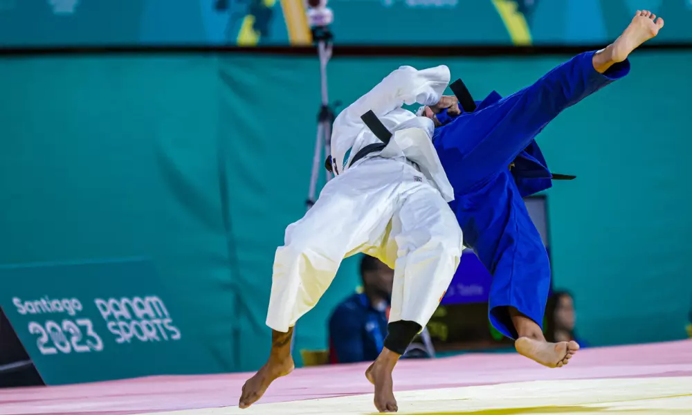 Rafaela Silva projeta adversária, sob fundo do backdrop de Santiago-2023