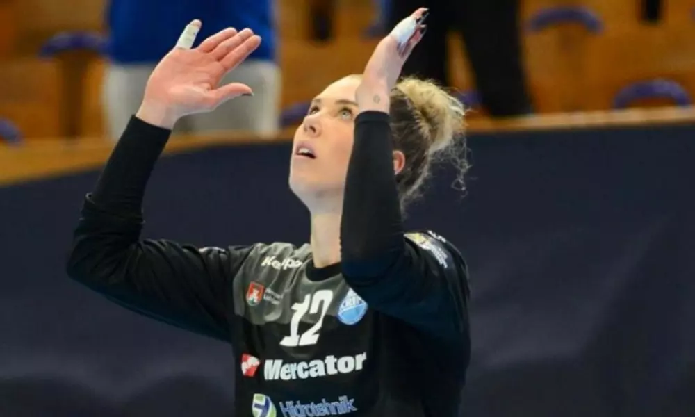 Babi Arenhart, goleira do Krim Mercator, ergue as mãos para o céu em partida da Champions League de handebol feminino