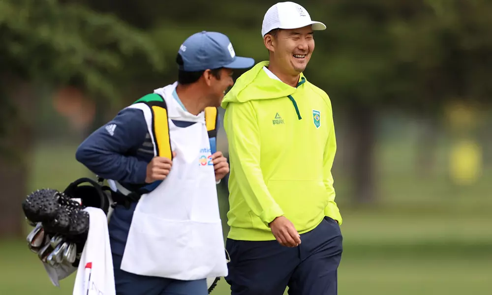 Na imagem, Rodrigo Lee e seu caddie, levando os tacos.