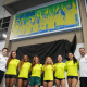 Lorrane Oliveira, Rebeca Andrade, Jade Barbosa, Flávia Saraiva, Julia Soares, Carolyne Pedro e treinadores posam para foto com painel do CT da ginástica no CT Do Time Brasil
