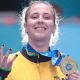 Danielle Rauen segura medalha de ouro e faz o número três com os dedos