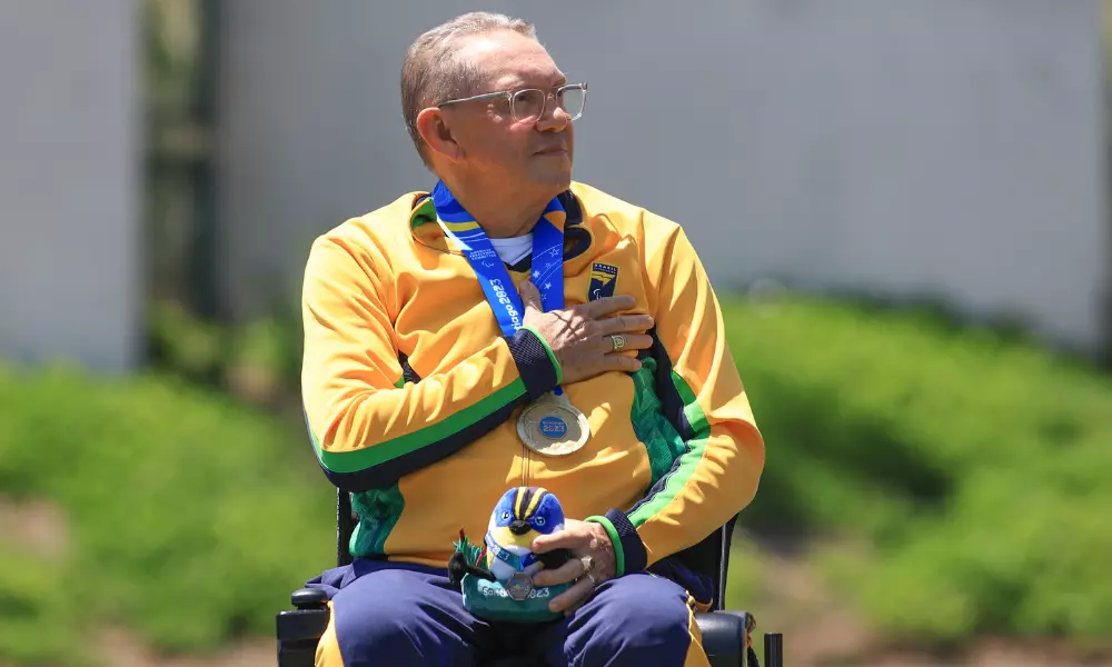 Eugênio Franco com a medalha de ouro no pescoço e a mão no peito durante a execução do hino nacional