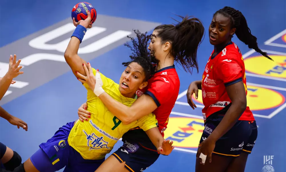 Ana Paula em meio a jogadoras da Dinamarca para finalizar em partida do Mundial de Handebol feminino