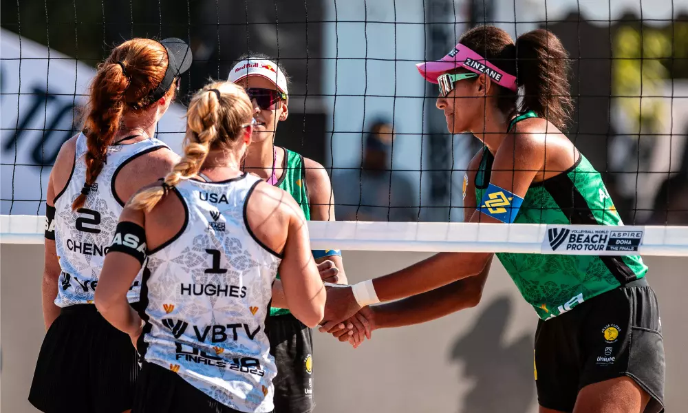 Duda e Ana Patrícia cumprimentam Hughes/Cheng na rede após partida no Finals de vôlei de praia