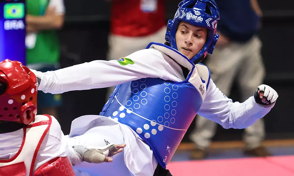 Na imagem, Milena Titoneli do taekwondo aplicando um chute na adversária.