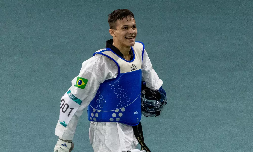 Nathan Torquato segura o capacete e sorri, para o alto. Ele garantiu uma vaga para o Brasil no parataekwondo dos Jogos Paralímpicos de Paris-2024
