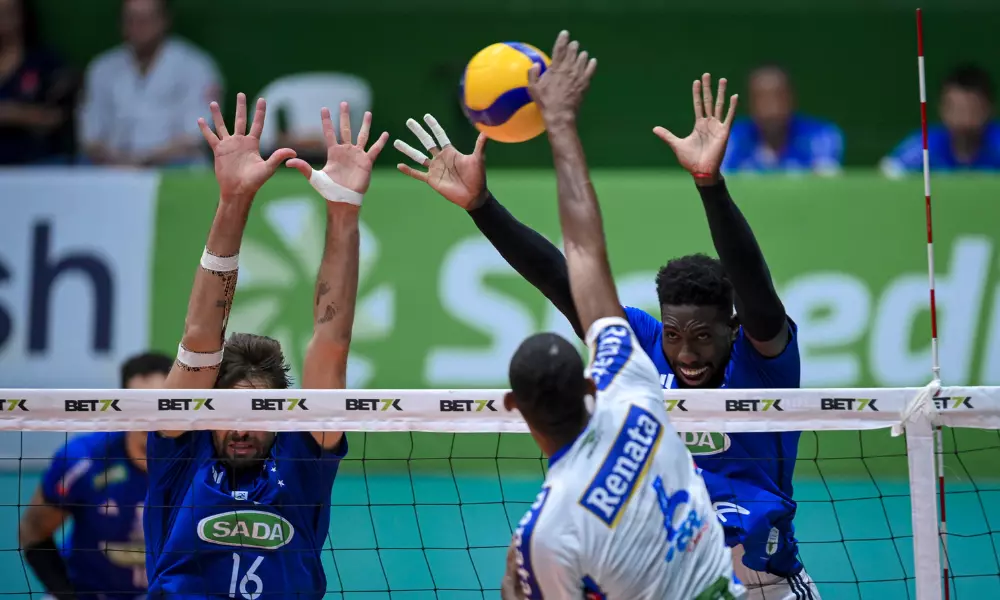 Jogador do Vôlei Renata ataca, enquanto dois do Sada Cruzeiro bloqueiam pela Superliga de vôlei masculino - Copa Brasil ao vivo (Foto: Agência i7)