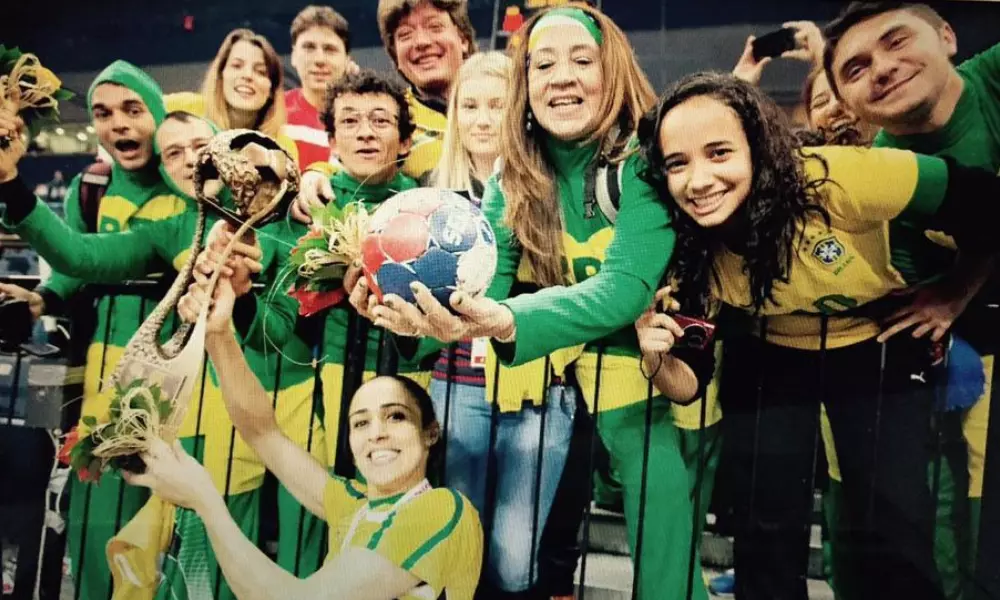 Chapolins e jogadora da seleção brasileira de handebol posam para foto com a taça