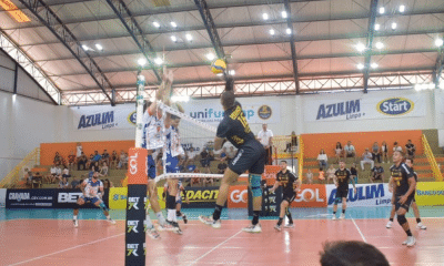 Jogador do Guarulhos ataca contra o bloqueio do Monte Carmelo em jogo da Superliga Masculina de vôlei