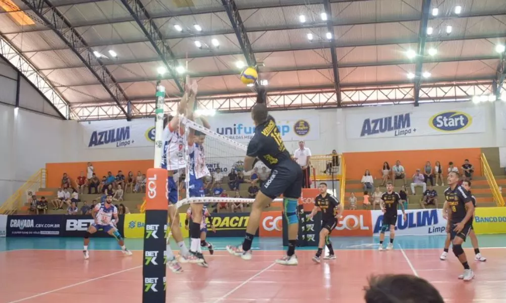 Jogador do Guarulhos ataca contra o bloqueio do Monte Carmelo em jogo da Superliga Masculina de vôlei