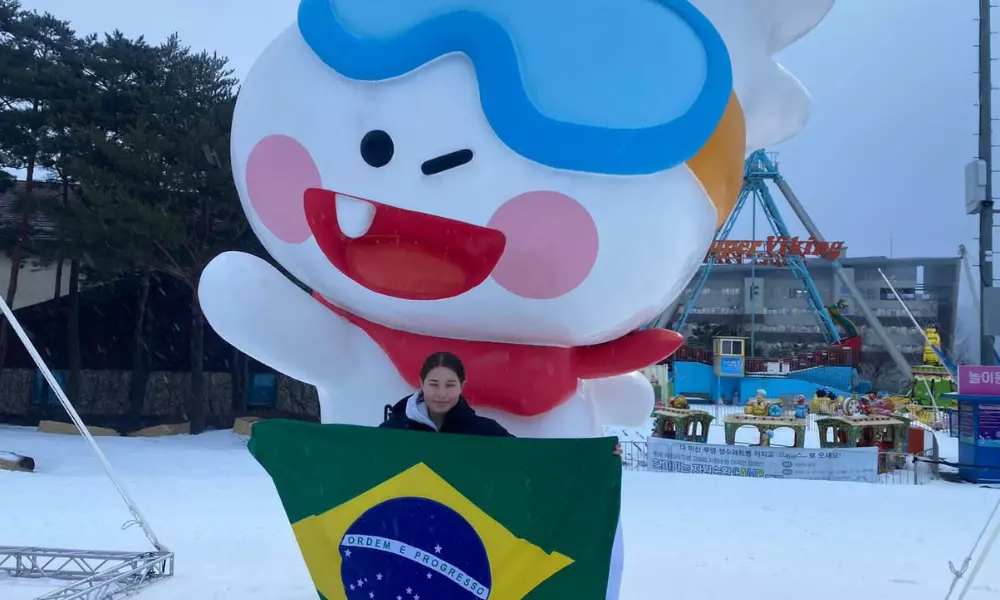 Alice Padilha em frente ao mascote dos Jogos Olímpicos de Inverno da Juventude