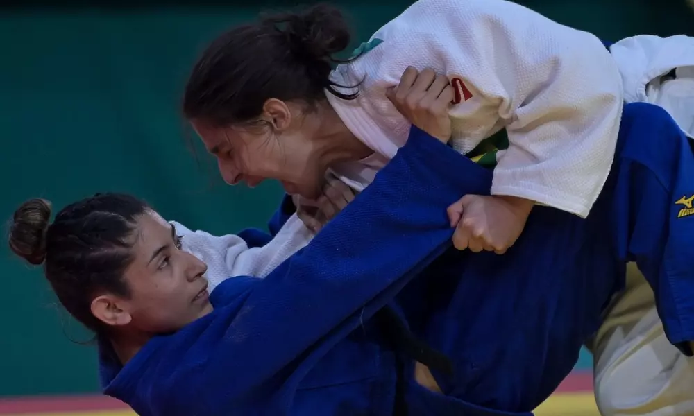 Giulia Pereira tem o corpo apoiado sobre a atleta argentina Rocio Ledesma, deitada no tatame com o rosto virado em direção à brasileira, que grita ao fim do golpe, no Parapan de Santiago. Foto: Washington Alves/CPB