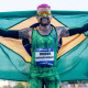 Vinicius Rodrigues com a bandeira do Brasil enquanto sorri para foto; ele está no BBB 24 e teve o pagamento do Bolsa Atleta suspenso