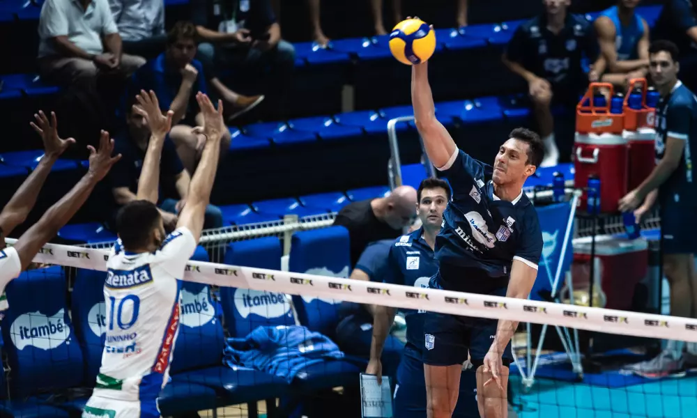 Jogador do Minas ataca sobre o bloqueio do vôlei renata em jogo da Superliga valendo vaga na Copa Brasil de vôlei masculino