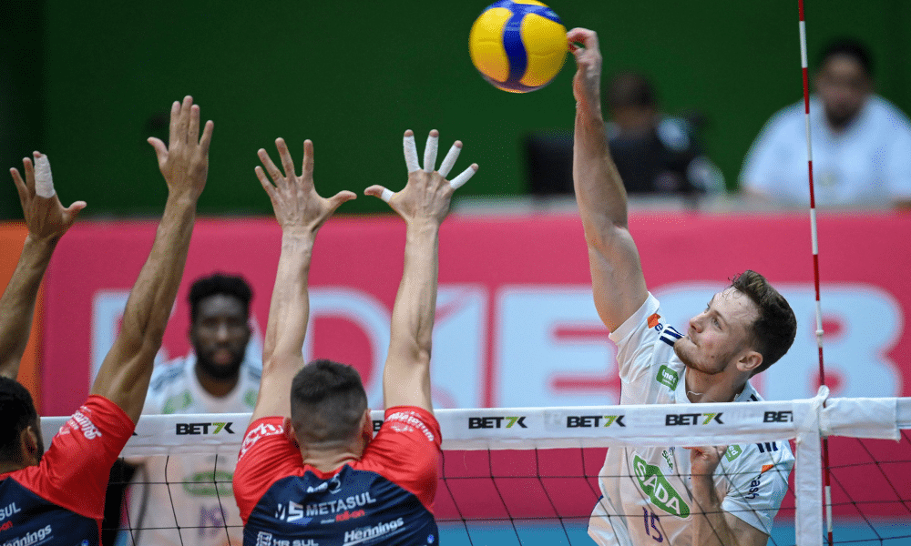 Vaccari, do Sada Cruzeiro, ataca contra o bloqueio do Apan Blumenau em jogo da Superliga Masculina de vôlei