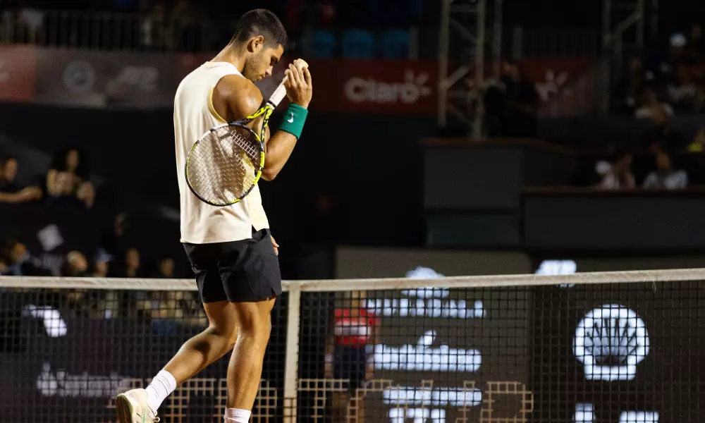 Carlos Alcaraz está cabisbaixo e indo para rede declarar sua desistência da partida contra Thiago Monteiro no Rio Open